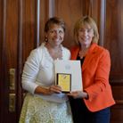 Govenor Hassan (right) presents Robin Carlson with the award in the Individual category.